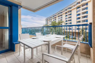 a table and chairs on a balcony with a view of a building at ApartUP Patacona Iconic II in Valencia
