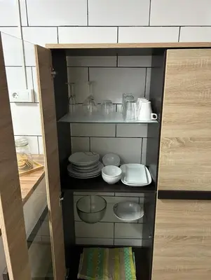 a cabinet with plates and bowls and other items in it at Mi refugio en la playa in Moncófar