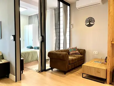 a living room with a couch and a bed at Encantador apartamento boutique a 5 min del metro in Bétera