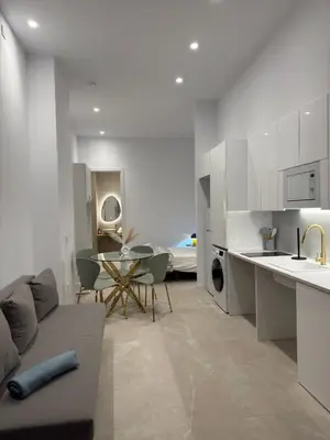 a kitchen and living room with a couch and a table at MAGNO- Beach in Valencia