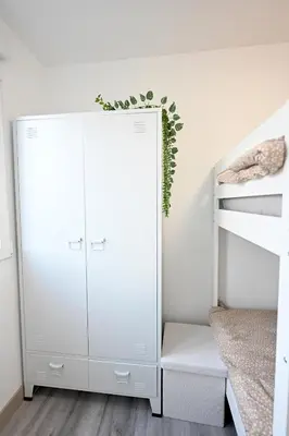 a white bedroom with a bunk bed and a white closet at El sonido del mar in Puerto de Sagunto