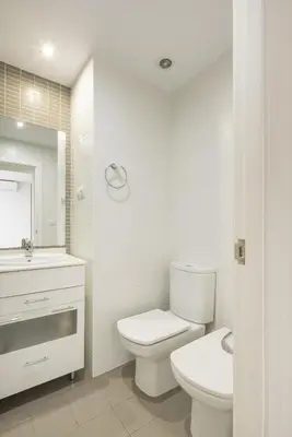 a white bathroom with a toilet and a sink at Fantastic beach apartment near Valencia in Valencia