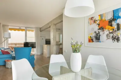 a living room with a glass table and white chairs at Fantastic beach apartment near Valencia in Valencia