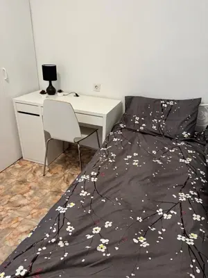 a bedroom with a bed with a desk and a bedspread with flowers at Hogar Mediterráneo in Valencia