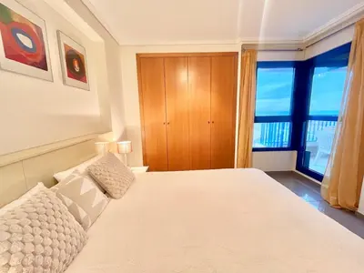 a bedroom with a bed and a large window at Complejo de playa in Valencia