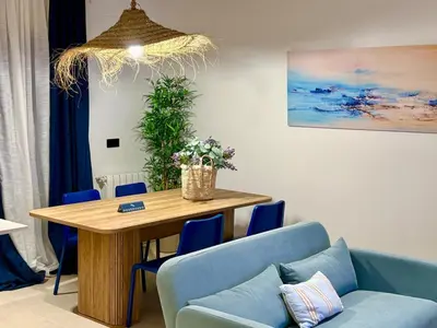 a dining room with a table and blue chairs at Family Home Valencia in Aldaia