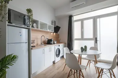 a kitchen with a white refrigerator and a table at Flats Uruguay in Valencia