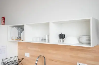 a kitchen with white cabinets with plates and dishes at Flats Uruguay in Valencia