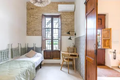 a bedroom with a bed and a wooden door at SeaFront Casa Valencia in Valencia