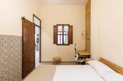 a bedroom with a bed and a desk and a chair at SeaFront Casa Valencia in Valencia