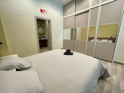 a large white bed in a room with a mirror at Fabuloso apartamento en Ruzafa in Valencia