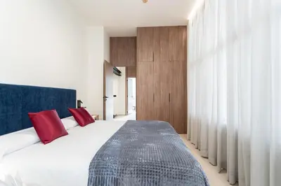 a bedroom with a large white bed with red pillows at Aqua Suites Ciudad de las Artes II in Valencia