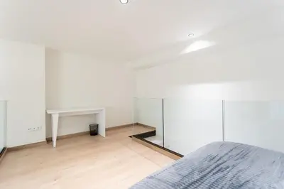 a bedroom with a bed and a desk and a mirror at Aqua Suites Ciudad de las Artes II in Valencia