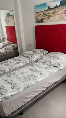 a bedroom with two beds and a red headboard at Stylish and renovated house in Cullera