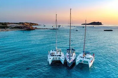 three boats are docked in the water in the ocean at Barco para dormir sobre el Mar in Valencia