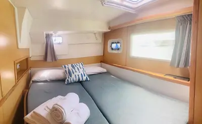 a small room with two beds and a window at Catamaran Nora in Puebla de Farnals