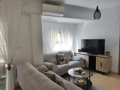 a living room with a table with chairs and a television at Apartamento playa Valencia in Mareny Barraquetas