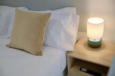 a bed with white pillows and a lamp on a night stand at Romantic Suite Roig Arena N4 Virkin Suites in Valencia