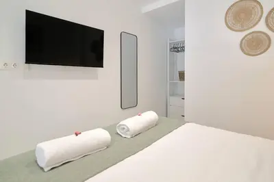 a white bedroom with two towels on a bed at Romantic Suite Roig Arena N4 Virkin Suites in Valencia