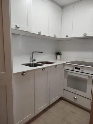 a kitchen with white cabinets and a sink at Cullera Playa de los Olivos Apartment in Faro de Cullera