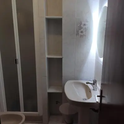 a white bathroom with a sink and a toilet at Apartamento primera línea Cullera in Cullera