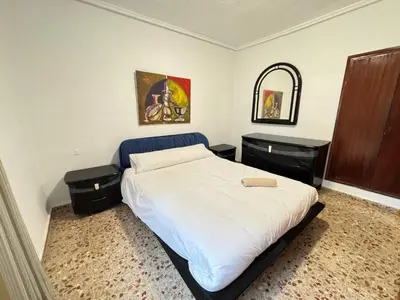 a bedroom with a bed and a chair in it at La casa del señorito in Tous