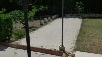 a sidewalk with two poles in the middle of a yard at Casa Kiosko 1 bedroom ground floor with swimming pool in La Eliana