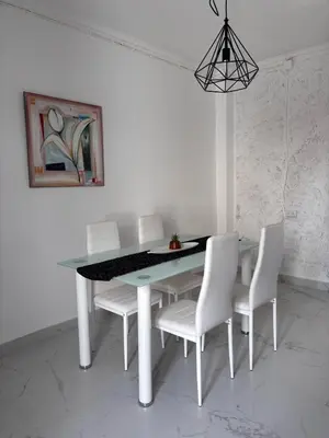 a dining room with a table and white chairs at A vacation by the sea in Puerto de Sagunto