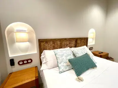 a bedroom with a white bed with an arched headboard at Pepitos House in Valencia
