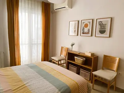 a bedroom with a bed and two chairs at Domus Belle Home Valencia in Foyos