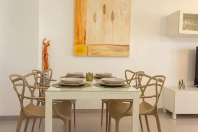a white dining room table with chairs and a painting at Beachfront apartment Cullera Espacio in Cullera