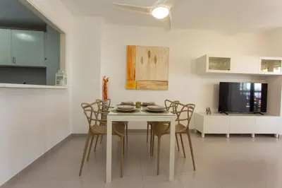 a kitchen and dining room with a table and chairs at Beachfront apartment Cullera Espacio in Cullera