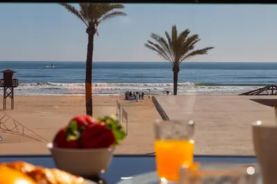 a table with food and a view of the beach at Beachfront apartment Cullera Espacio in Cullera