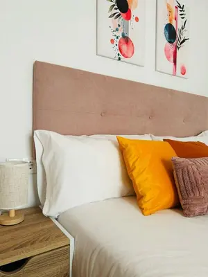 a bed with orange and white pillows next to a table at ABAT 2 Cool & Wide Flat next to the Cathedral in Valencia