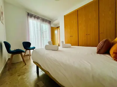 a bedroom with a large bed with two chairs and a window at ABAT 2 Cool & Wide Flat next to the Cathedral in Valencia