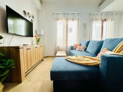 a living room with a blue couch and a flat screen tv at ABAT 3 Cool & Wide Duplex Next to the Cathedral in Valencia