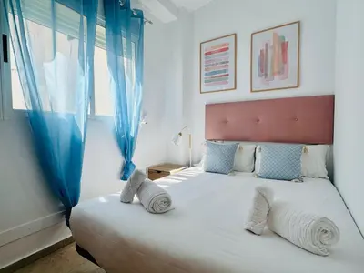 a bedroom with a large white bed with blue curtains at ABAT 3 Cool & Wide Duplex Next to the Cathedral in Valencia