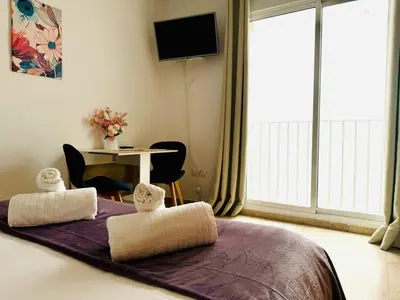 a bedroom with a bed with two towels on it at ABAT 4 Cool & Wide Studio in the Historic Center in Valencia