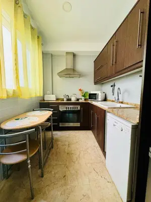 a kitchen with wooden cabinets and a table in it at ABAT 4 Cool & Wide Studio in the Historic Center in Valencia