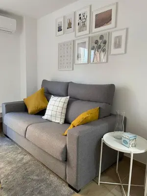 a gray couch in a living room with a table at Where You Feel Home in Godella