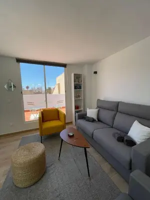 a living room with a gray couch and a yellow chair at More then a bright studio in Godella