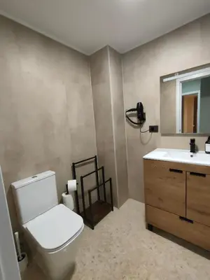 a bathroom with a toilet and a sink and a mirror at Playa Paradis III - Primera linea de playa in Moncófar