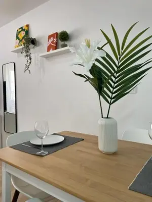 a table with a vase with white flowers on it at White Lily in Godella