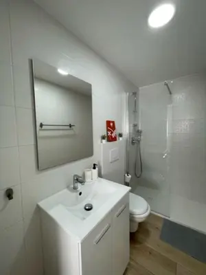 a bathroom with a sink and a toilet and a mirror at White Lily in Godella