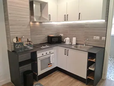 a kitchen and a living room with a couch and a table at Coqueto apartmento en Valencia in Valencia