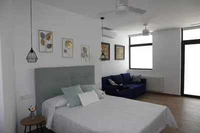 a bedroom with a bed and a blue couch at Ruzafa Alegria in Valencia