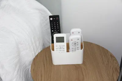 a table with two remote controls sitting on top of a bed at Ruzafa Alegria in Valencia