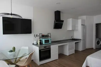 a white kitchen with a table and a microwave at Ruzafa Alegria in Valencia