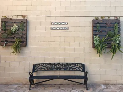 a bench sitting in front of a brick wall with plants at Brisas del Lago in Navarrés