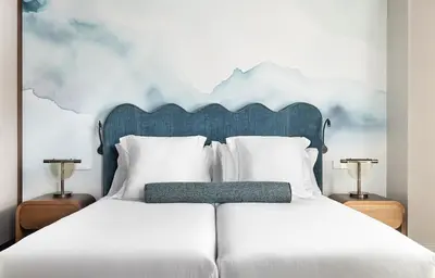 a bedroom with a white bed with a blue headboard at One Shot Puerta Ruzafa in Valencia